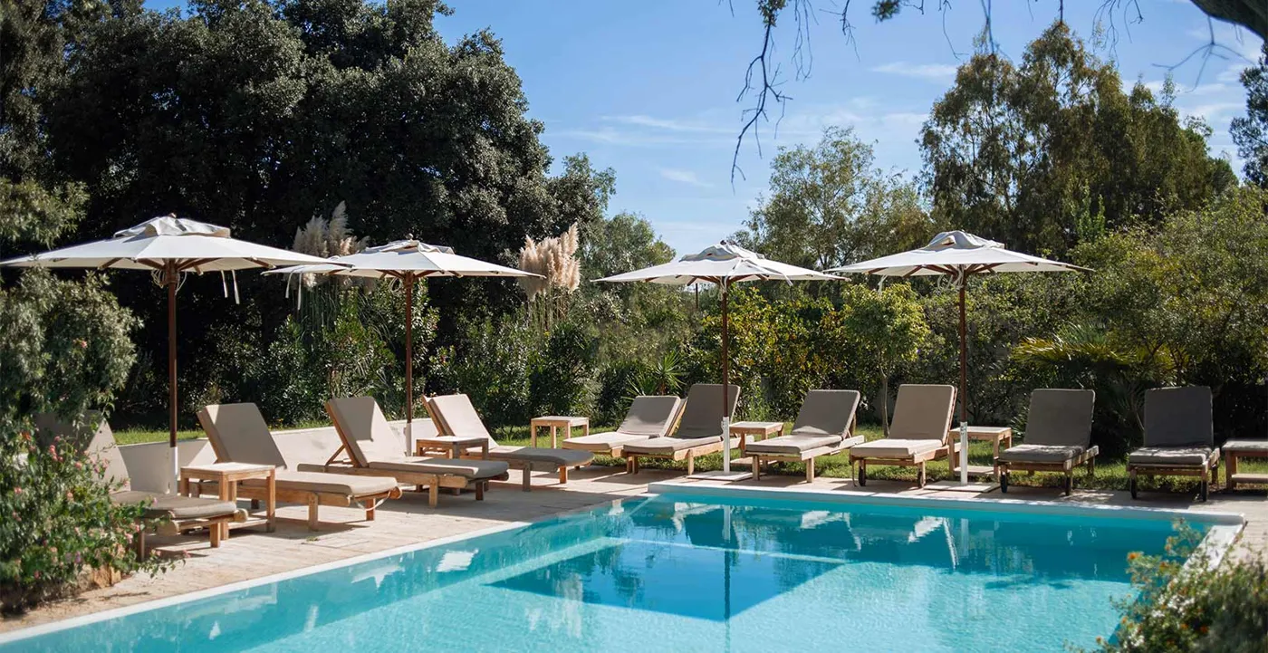 Lanthia Resort pool with parasols and mountains behind